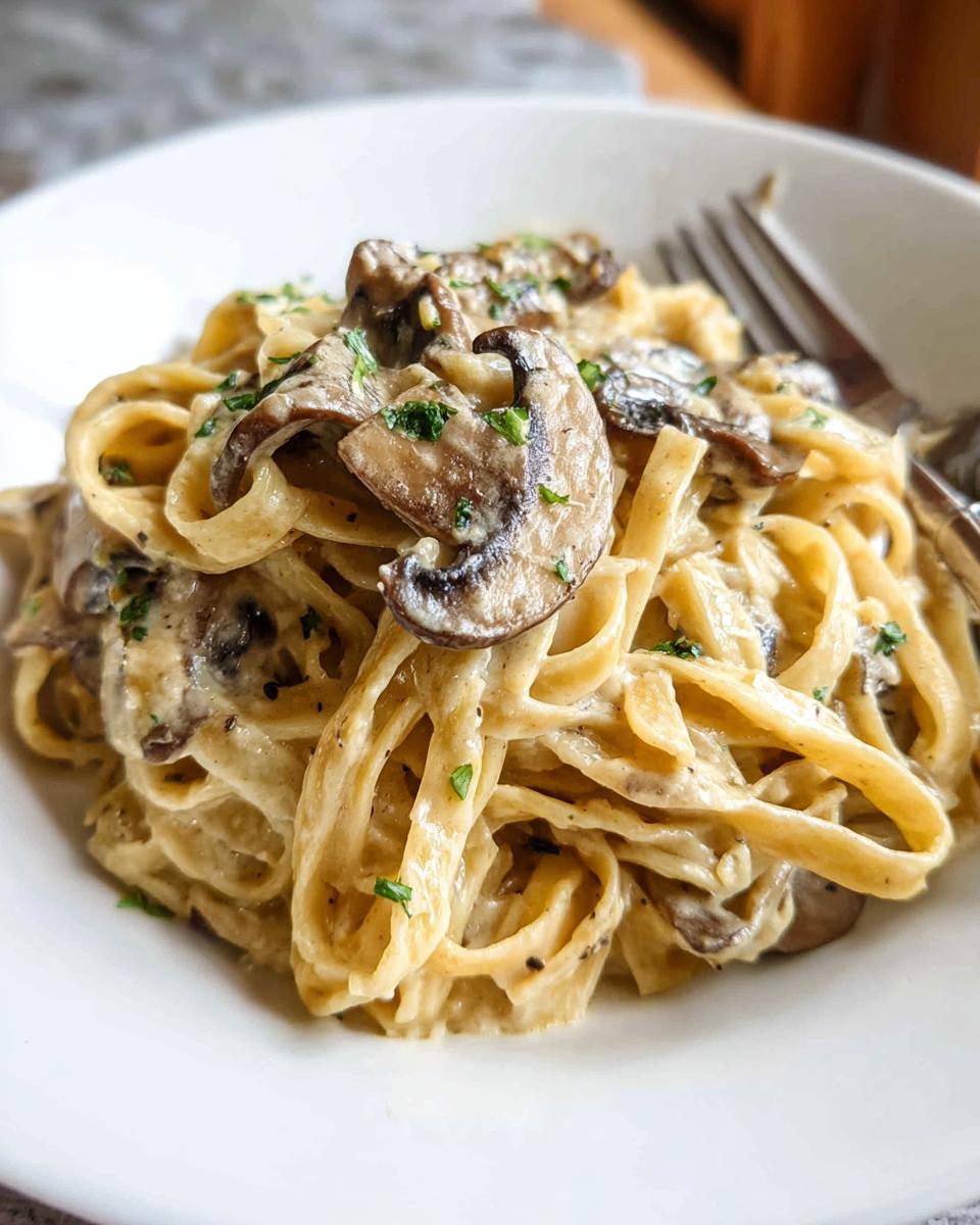 Close-up of creamy mushroom pasta with fettuccine noodles and sliced mushrooms, perfect for Creamy Pasta Nights.